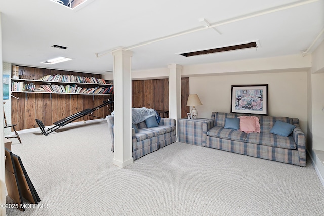 carpeted living room with baseboards and ornate columns