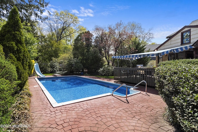 pool with a water slide and a patio area