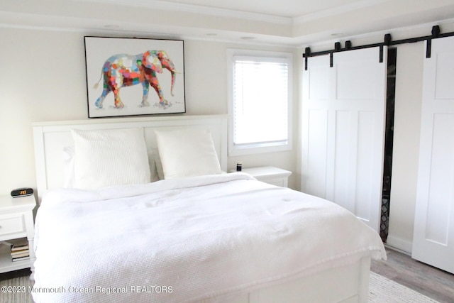 23 Layton Ave, Pine Beach, NJ 08741 - bedroom featuring a barn door, light wood-style flooring, and crown molding