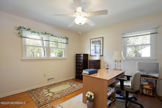 office area with baseboards, a ceiling fan, wood finished floors, and visible vents