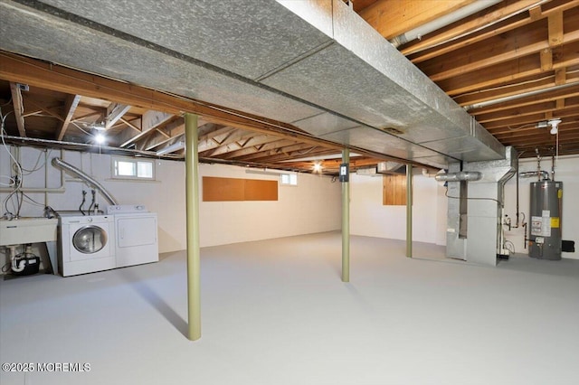 basement with a sink, heating unit, gas water heater, and washing machine and dryer