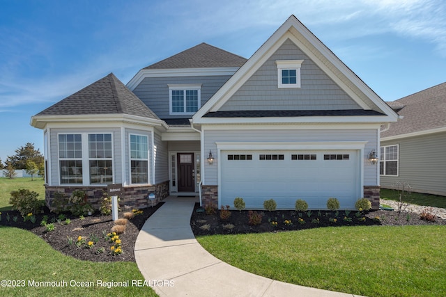 craftsman house with a front lawn, roof with shingles, and stone siding