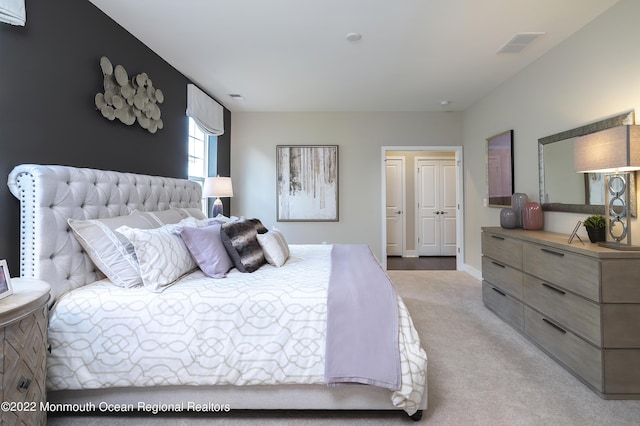 bedroom featuring visible vents and light carpet