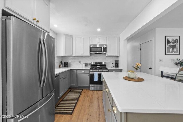 113 Darien Rd, Howell, NJ 07731 - kitchen with appliances with stainless steel finishes, gray cabinetry, light wood-style flooring, tasteful backsplash, and recessed lighting
