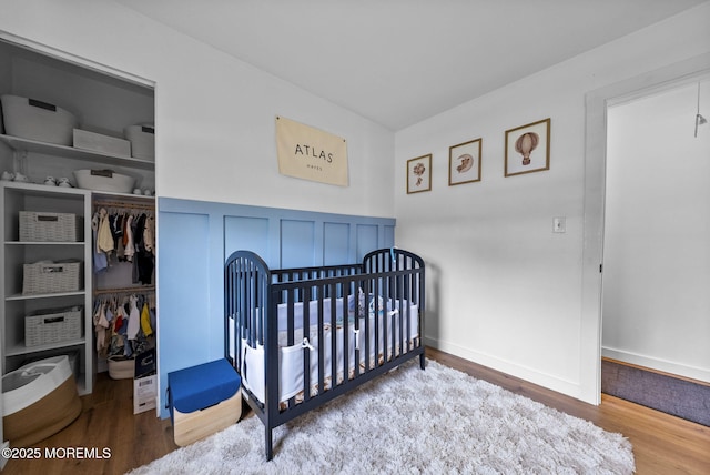 113 Darien Rd, Howell, NJ 07731 - bedroom featuring wood finished floors, a closet, a nursery area, and wainscoting