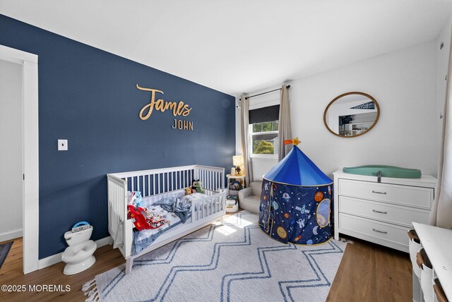 113 Darien Rd, Howell, NJ 07731 - bedroom featuring wood finished floors, a nursery area, and baseboards
