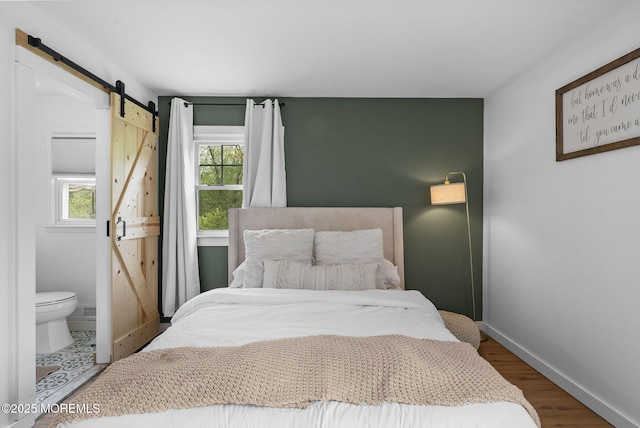 113 Darien Rd, Howell, NJ 07731 - bedroom featuring a barn door, baseboards, wood finished floors, and ensuite bath