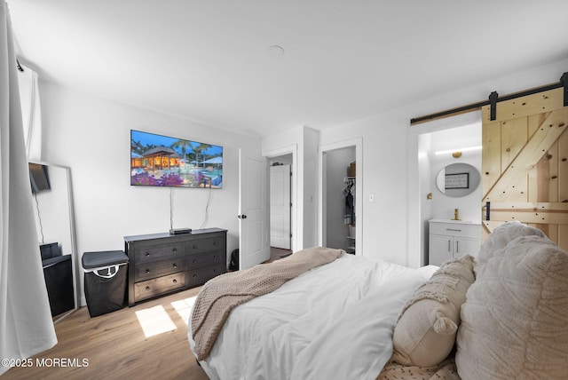 113 Darien Rd, Howell, NJ 07731 - bedroom with a barn door, light wood-type flooring, a spacious closet, and a closet
