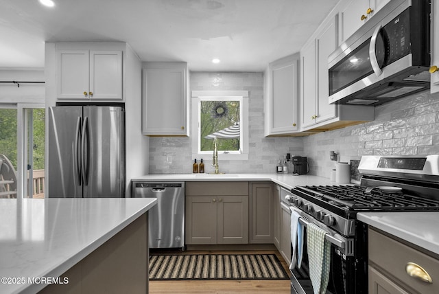 113 Darien Rd, Howell, NJ 07731 - kitchen with stainless steel appliances, a sink, light countertops, decorative backsplash, and gray cabinets