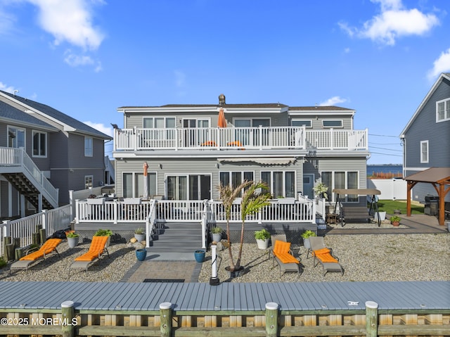 back of property with a deck and a balcony