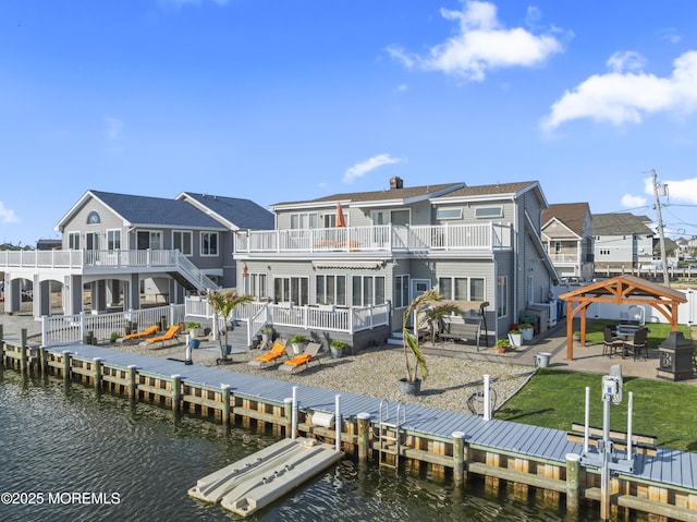 rear view of property featuring a gazebo, a fenced backyard, a water view, a balcony, and a patio
