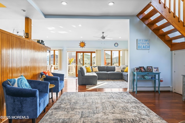 living room featuring plenty of natural light, ceiling fan, a baseboard heating unit, and wood finished floors