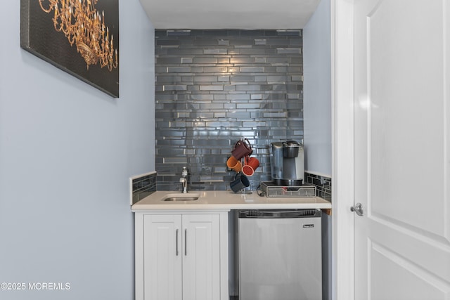 bar featuring a sink, wet bar, backsplash, and fridge