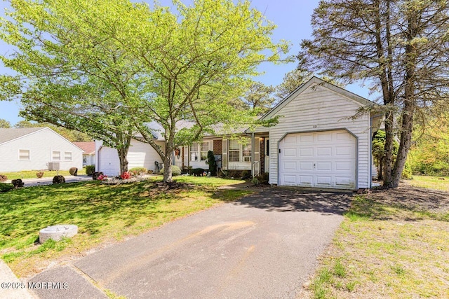 single story home featuring an attached garage, a front lawn, and aphalt driveway