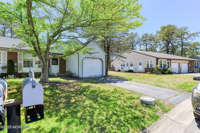 single story home with brick siding, a front lawn, and driveway