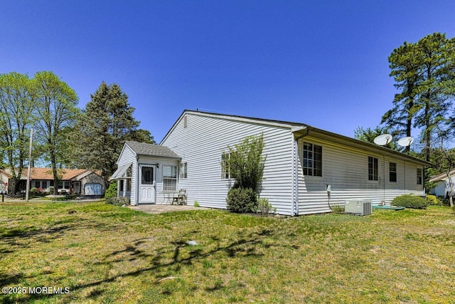 rear view of property with a lawn and central AC unit