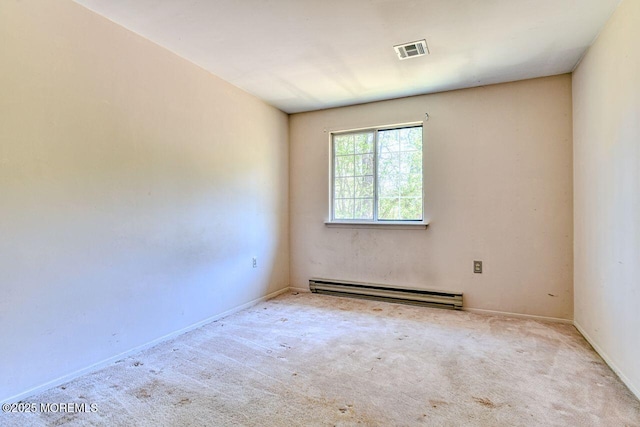 spare room featuring baseboards, a baseboard heating unit, carpet flooring, and visible vents