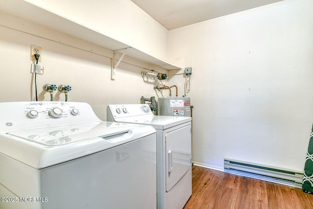 laundry area with light wood-style floors, laundry area, baseboards, water heater, and separate washer and dryer
