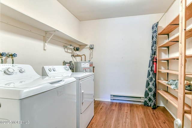 clothes washing area with gas water heater, laundry area, washing machine and dryer, a baseboard heating unit, and light wood-style flooring