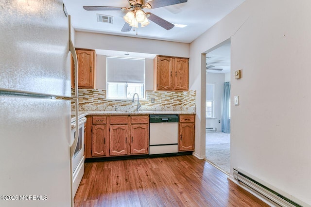 kitchen with ceiling fan, visible vents, wood finished floors, a baseboard heating unit, and white appliances