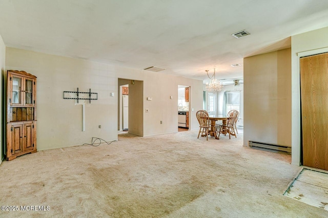 carpeted living area with visible vents, a baseboard heating unit, and a chandelier