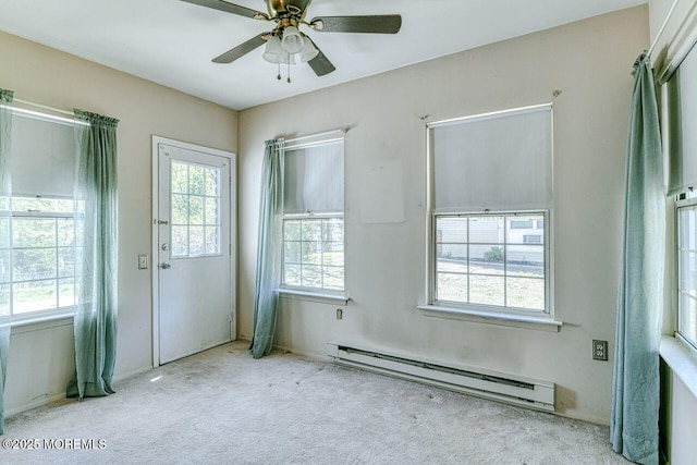 empty room featuring carpet floors, baseboards, a ceiling fan, and a baseboard heating unit