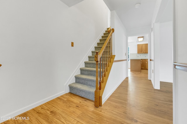 stairway featuring wood finished floors and baseboards