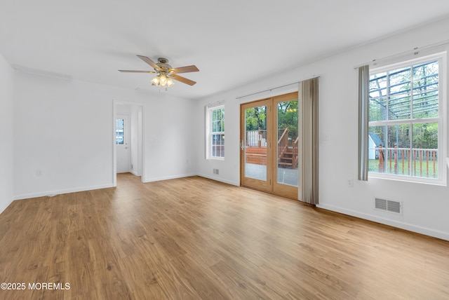 unfurnished room featuring light wood-style floors, visible vents, baseboards, and a ceiling fan
