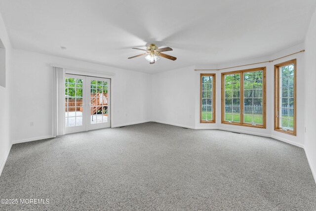 carpeted empty room with baseboards, a ceiling fan, and french doors