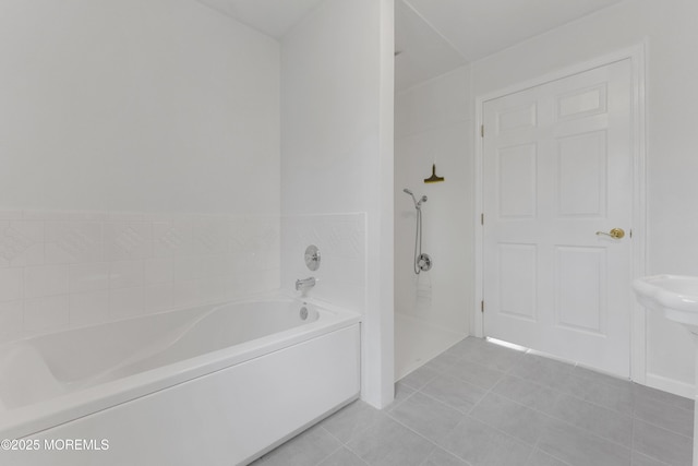 full bathroom featuring walk in shower, a garden tub, and tile patterned flooring