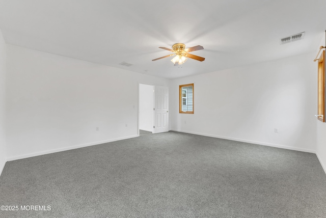 unfurnished room with a ceiling fan, dark carpet, and visible vents