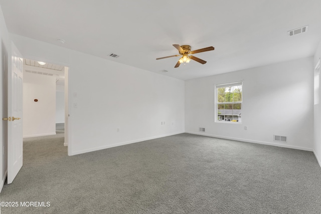 unfurnished room with a ceiling fan, visible vents, and carpet floors