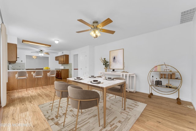 dining room featuring a ceiling fan, visible vents, and light wood-style floors