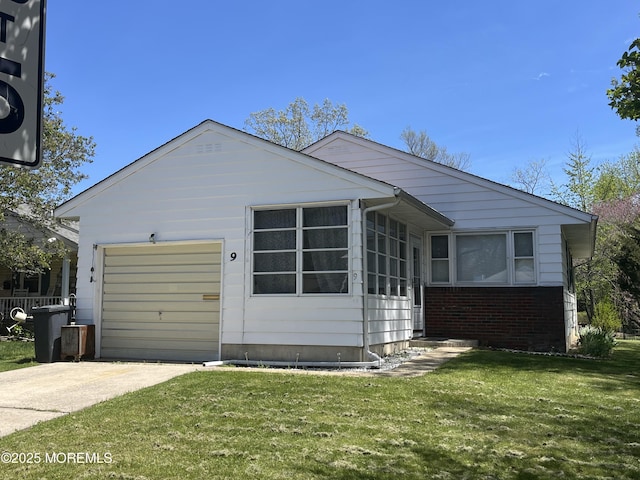 view of property exterior featuring a yard, a sunroom, brick siding, concrete driveway, and an attached garage