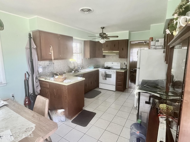 kitchen featuring light tile patterned floors, tasteful backsplash, under cabinet range hood, visible vents, and white electric range