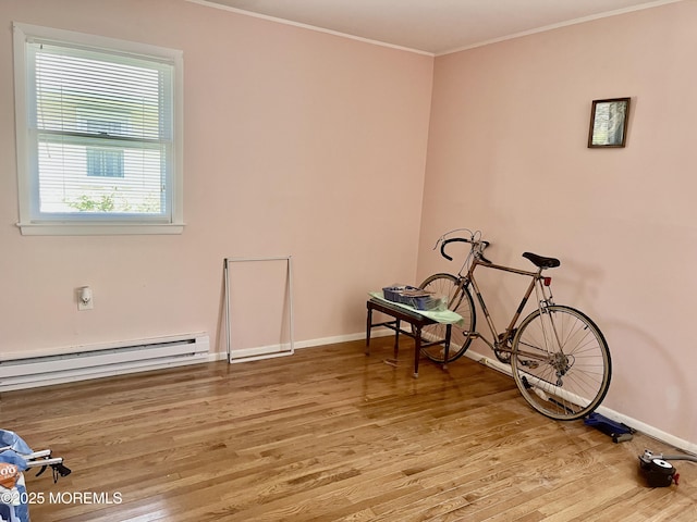 interior space with baseboards, a baseboard heating unit, and wood finished floors