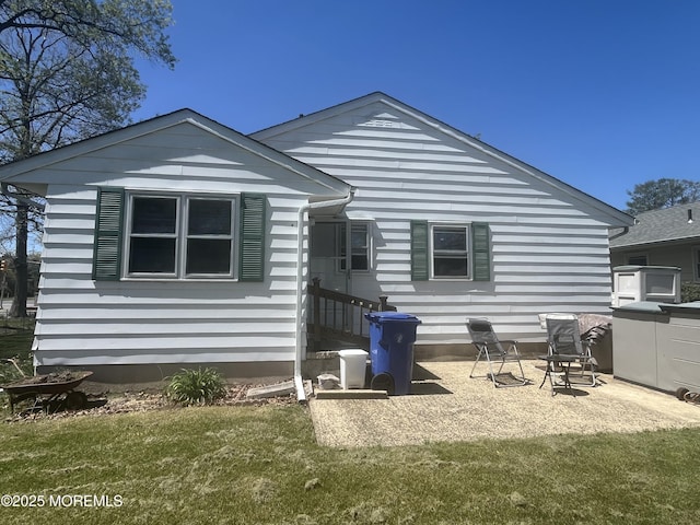 rear view of property with a lawn and a patio area