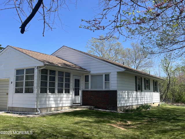 view of front of house with a sunroom, a front lawn, brick siding, and entry steps