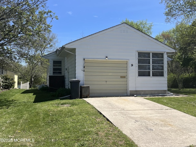 view of property exterior with an attached garage, a yard, and driveway