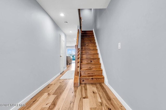 stairs with baseboards, recessed lighting, and wood finished floors