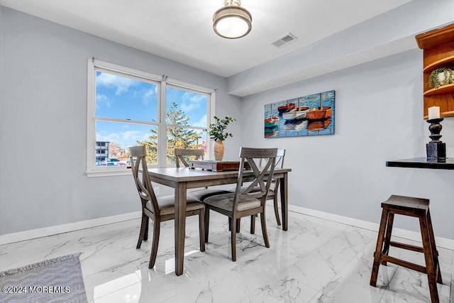 dining room featuring baseboards, marble finish floor, and visible vents