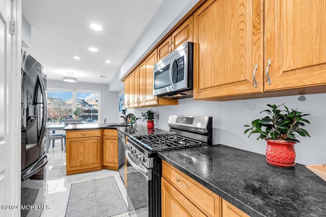 kitchen featuring dark countertops, brown cabinetry, stainless steel appliances, recessed lighting, and a peninsula