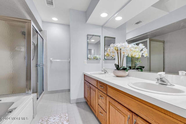 full bath with visible vents, a sink, double vanity, and a shower stall