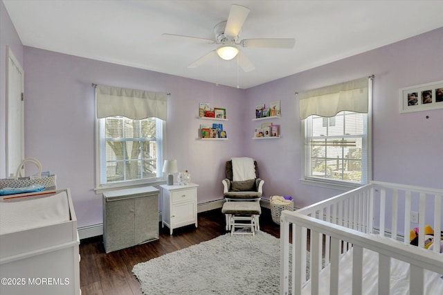 bedroom with dark wood-style flooring, multiple windows, and baseboard heating