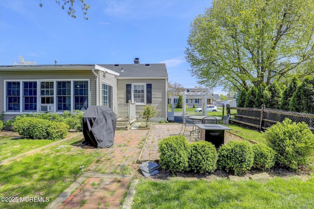 rear view of house with fence, a patio, a chimney, and cooling unit
