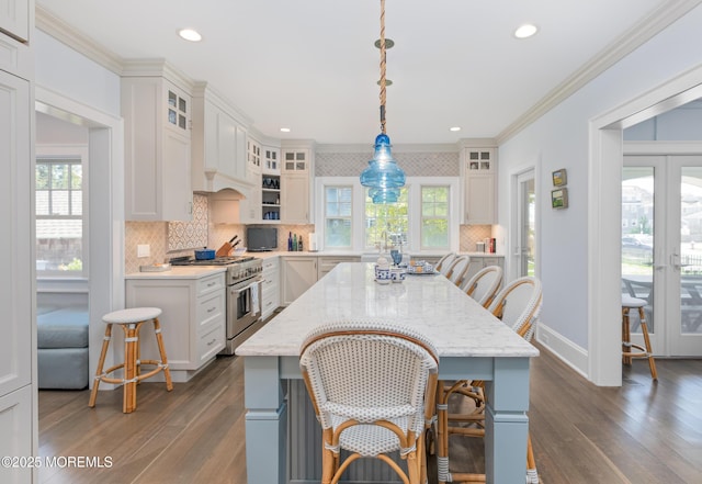 26 Bridge, Bay Head, NJ 08742 - kitchen featuring high end stainless steel range oven, dark wood-style flooring, decorative backsplash, a kitchen breakfast bar, and white cabinetry