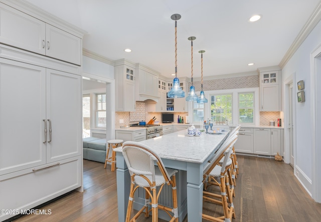 26 Bridge, Bay Head, NJ 08742 - kitchen featuring high end stove, ornamental molding, a kitchen bar, tasteful backsplash, and dark wood-style flooring
