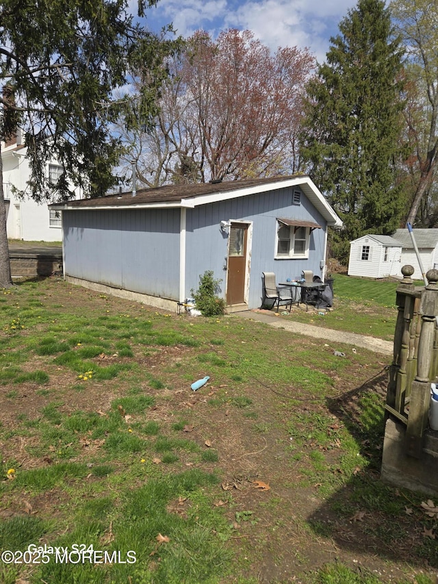 back of property featuring an outbuilding and a yard
