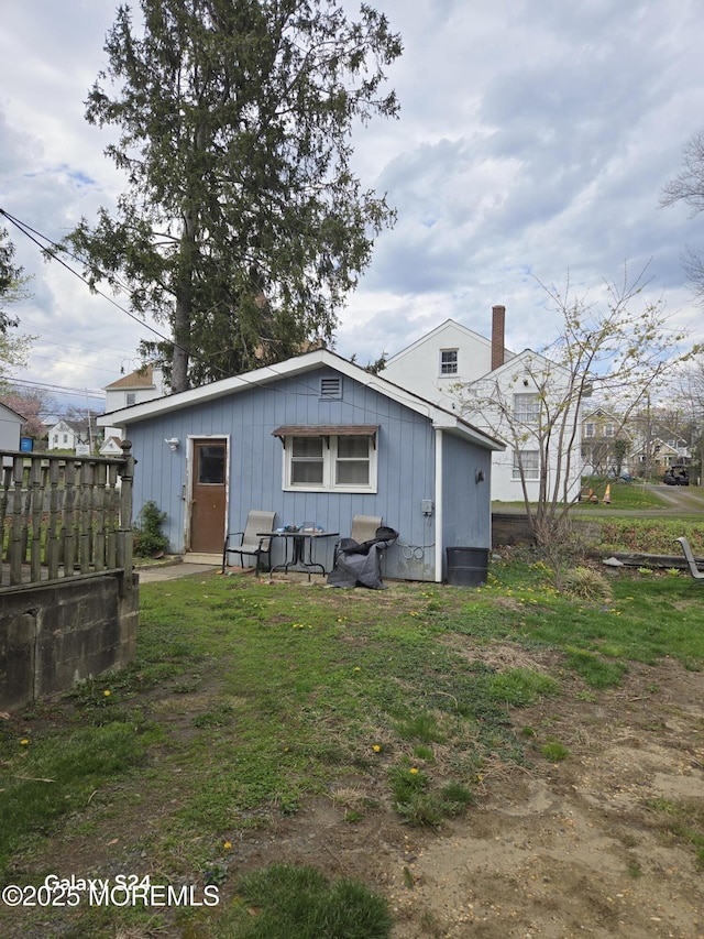 rear view of house with board and batten siding and a chimney