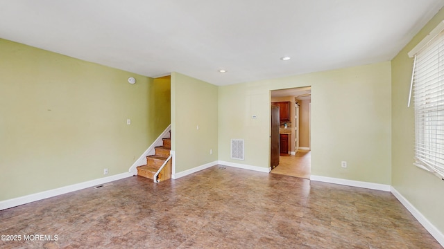 empty room featuring recessed lighting, baseboards, visible vents, and stairway